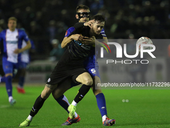 Sam Lavelle of Carlisle United holds back Joe Hugill of Wigan Athletic during the FA Cup First Round match between Carlisle United and Wigan...