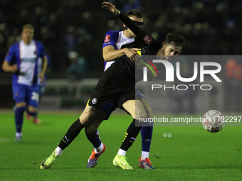 Sam Lavelle of Carlisle United holds back Joe Hugill of Wigan Athletic during the FA Cup First Round match between Carlisle United and Wigan...