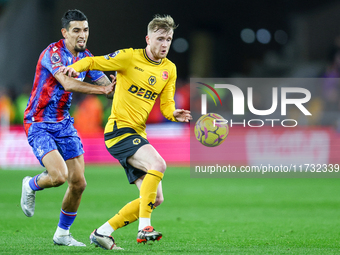 Number 20, Tommy Doyle of Wolves, is pressed by number 12, Daniel Munoz of Crystal Palace during the Premier League match between Wolverhamp...