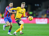 Number 20, Tommy Doyle of Wolves, is pressed by number 12, Daniel Munoz of Crystal Palace during the Premier League match between Wolverhamp...