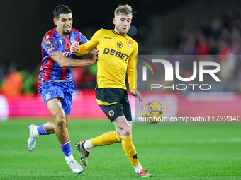 Number 20, Tommy Doyle of Wolves, is pressed by number 12, Daniel Munoz of Crystal Palace during the Premier League match between Wolverhamp...