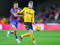 Number 20, Tommy Doyle of Wolves, is pressed by number 12, Daniel Munoz of Crystal Palace during the Premier League match between Wolverhamp...