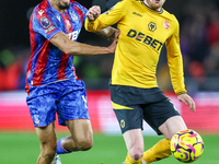 Number 20, Tommy Doyle of Wolves, is pressed by number 12, Daniel Munoz of Crystal Palace during the Premier League match between Wolverhamp...