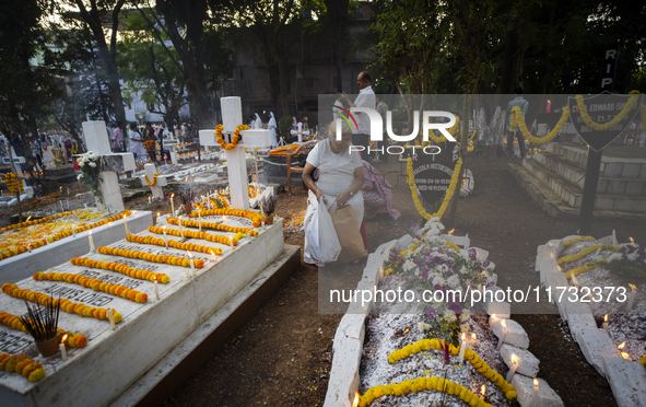 People from the Christian community light candles and offer prayers on the grave of their relative during the All Souls' Day observation in...