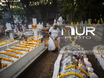 People from the Christian community light candles and offer prayers on the grave of their relative during the All Souls' Day observation in...