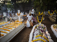 People from the Christian community light candles and offer prayers on the grave of their relative during the All Souls' Day observation in...