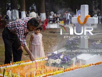 People from the Christian community light candles and offer prayers on the grave of their relative during the All Souls' Day observation in...