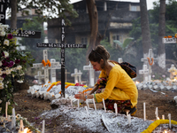 People from the Christian community light candles and offer prayers on the grave of their relative during the All Souls' Day observation in...