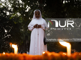 A nun offers prayers on the grave during the All Souls' Day observation in Guwahati, India, on November 2, 2024. All Souls' Day is a Christi...