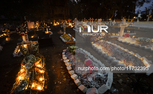 People from the Christian community light candles and offer prayers on the grave of their relative during the All Souls' Day observation in...