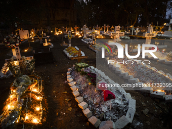 People from the Christian community light candles and offer prayers on the grave of their relative during the All Souls' Day observation in...