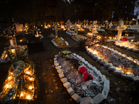 People from the Christian community light candles and offer prayers on the grave of their relative during the All Souls' Day observation in...