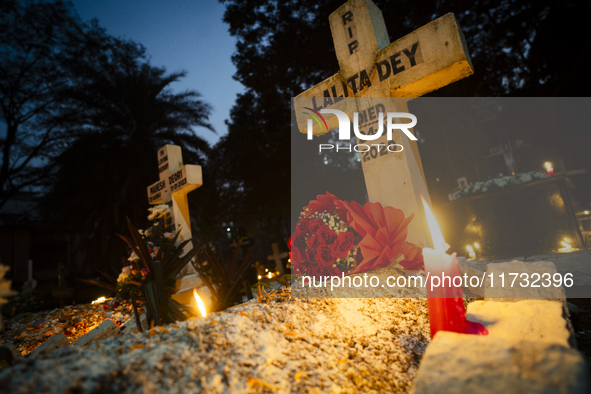 People from the Christian community light candles and offer prayers on the grave of their relative during the All Souls' Day observation in...