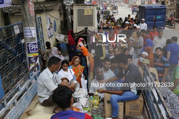 Lower-income people stand in a queue to buy government-subsidized food in Dhaka, Bangladesh, on November 2, 2024. 