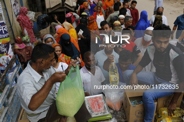 Lower-income people stand in a queue to buy government-subsidized food in Dhaka, Bangladesh, on November 2, 2024. 