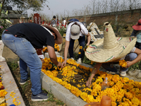 People attend the Tecomitl community pantheon in Mexico City, Mexico, on November 2, 2024, and decorate the graves of their deceased loved o...