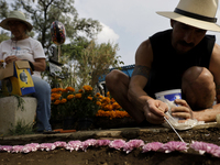 People attend the Tecomitl community pantheon in Mexico City, Mexico, on November 2, 2024, and decorate the graves of their deceased loved o...