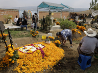 People attend the Tecomitl community pantheon in Mexico City, Mexico, on November 2, 2024, and decorate the graves of their deceased loved o...