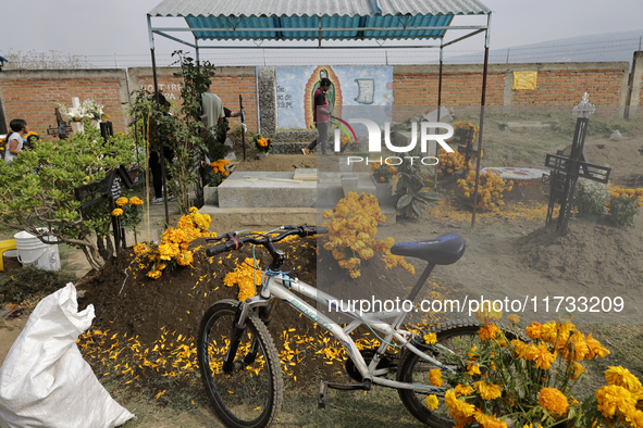 People attend the Tecomitl community pantheon in Mexico City, Mexico, on November 2, 2024, and decorate the graves of their deceased loved o...