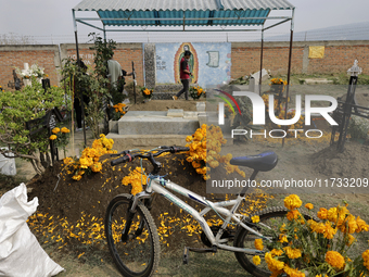 People attend the Tecomitl community pantheon in Mexico City, Mexico, on November 2, 2024, and decorate the graves of their deceased loved o...