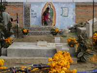 People attend the Tecomitl community pantheon in Mexico City, Mexico, on November 2, 2024, and decorate the graves of their deceased loved o...