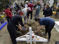 People attend the Tecomitl community pantheon in Mexico City, Mexico, on November 2, 2024, and decorate the graves of their deceased loved o...