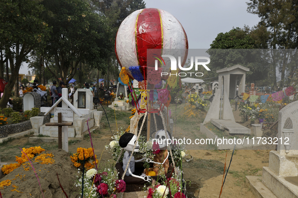 A view of a grave in the Tecomitl community pantheon in Mexico City, Mexico, on November 2, 2024, shows dozens of people decorating the grav...