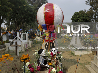 A view of a grave in the Tecomitl community pantheon in Mexico City, Mexico, on November 2, 2024, shows dozens of people decorating the grav...