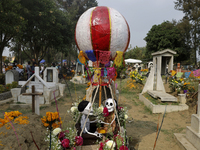 A view of a grave in the Tecomitl community pantheon in Mexico City, Mexico, on November 2, 2024, shows dozens of people decorating the grav...