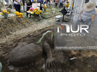 People attend the Tecomitl community pantheon in Mexico City, Mexico, on November 2, 2024, and decorate the graves of their deceased loved o...