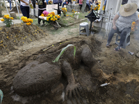 People attend the Tecomitl community pantheon in Mexico City, Mexico, on November 2, 2024, and decorate the graves of their deceased loved o...