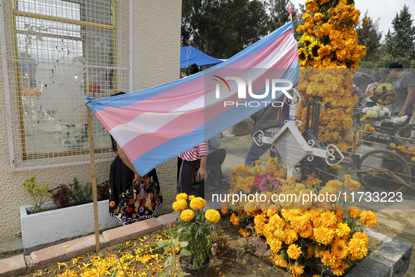 A view of a trans flag at the Tecomitl community cemetery in Mexico City, Mexico, on November 2, 2024, shows dozens of people decorating the...