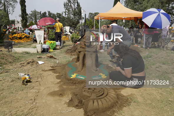 People attend the Tecomitl community pantheon in Mexico City, Mexico, on November 2, 2024, and decorate the graves of their deceased loved o...