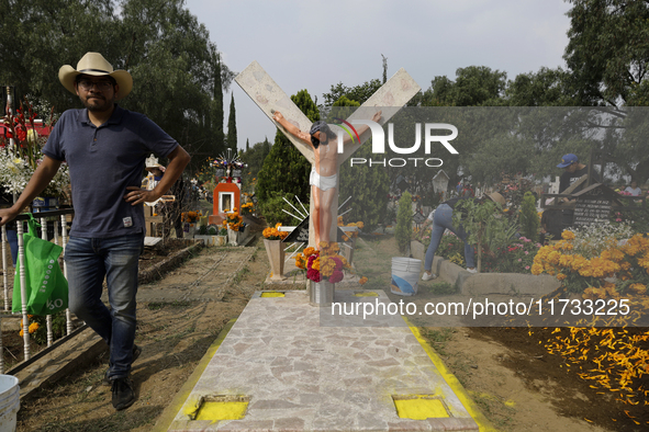 A view of a grave in the Tecomitl community pantheon in Mexico City, Mexico, on November 2, 2024, shows dozens of people decorating the grav...