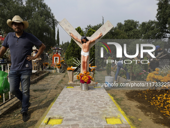 A view of a grave in the Tecomitl community pantheon in Mexico City, Mexico, on November 2, 2024, shows dozens of people decorating the grav...