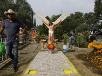 A view of a grave in the Tecomitl community pantheon in Mexico City, Mexico, on November 2, 2024, shows dozens of people decorating the grav...