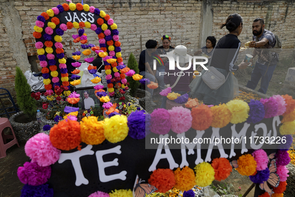 A view of a grave in the Tecomitl community pantheon in Mexico City, Mexico, on November 2, 2024, shows dozens of people decorating the grav...