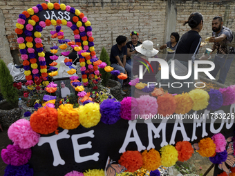 A view of a grave in the Tecomitl community pantheon in Mexico City, Mexico, on November 2, 2024, shows dozens of people decorating the grav...