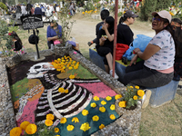 People attend the Tecomitl community pantheon in Mexico City, Mexico, on November 2, 2024, and decorate the graves of their deceased loved o...