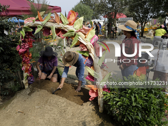 People attend the Tecomitl community pantheon in Mexico City, Mexico, on November 2, 2024, and decorate the graves of their deceased loved o...