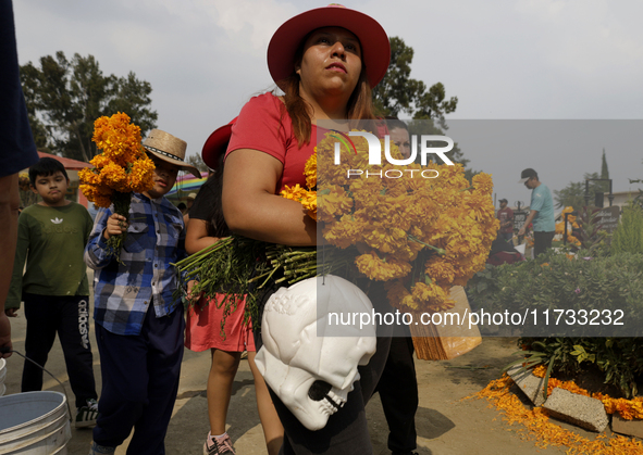 People attend the Tecomitl community pantheon in Mexico City, Mexico, on November 2, 2024, and decorate the graves of their deceased loved o...