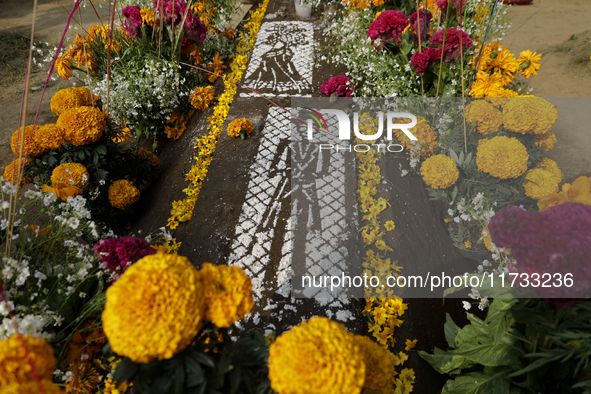 A view of a grave in the Tecomitl community pantheon in Mexico City, Mexico, on November 2, 2024, shows dozens of people decorating the grav...