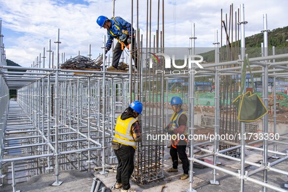 Workers work at the construction site of the Sichuan Can Invest Bazhong (Tongjiang) gas-fired power generation project in Jintang Industrial...