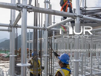 Workers work at the construction site of the Sichuan Can Invest Bazhong (Tongjiang) gas-fired power generation project in Jintang Industrial...