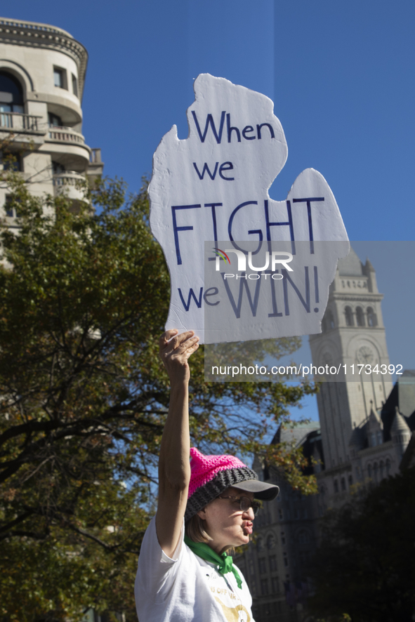 A person holds a sign during the National Women's March at Freedom Plaza in Washington DC, USA, on November 2, 2024. Just days before the US...