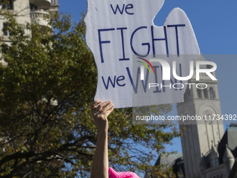 A person holds a sign during the National Women's March at Freedom Plaza in Washington DC, USA, on November 2, 2024. Just days before the US...