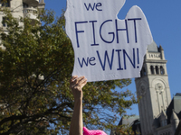 A person holds a sign during the National Women's March at Freedom Plaza in Washington DC, USA, on November 2, 2024. Just days before the US...