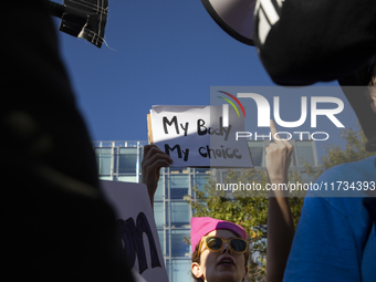 An abortion rights activist displays a sign during the National Women's March at Freedom Plaza in Washington DC, USA, on November 2, 2024. J...