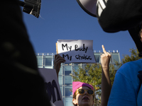 An abortion rights activist displays a sign during the National Women's March at Freedom Plaza in Washington DC, USA, on November 2, 2024. J...