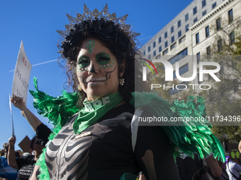 A person poses for photographs during the National Women's March at Freedom Plaza in Washington DC, USA, on November 2, 2024. Just days befo...